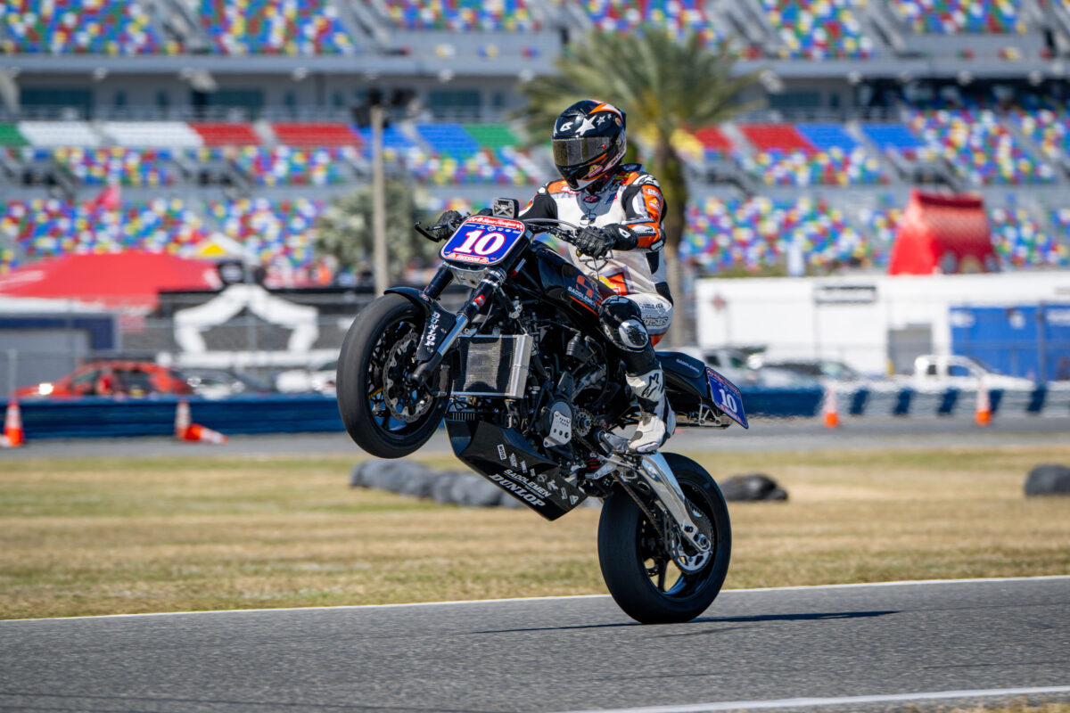 racing motorcycle doing a wheelie celebrating.
